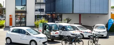 Verschiedene Fahrzeuge mit Elektromobilität aus einem kommunalen Fuhrpark: Autos, Fahrräder, Straßenreinigung