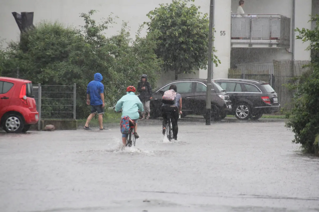 Fahrradfahrer auf überschwemmter Straße