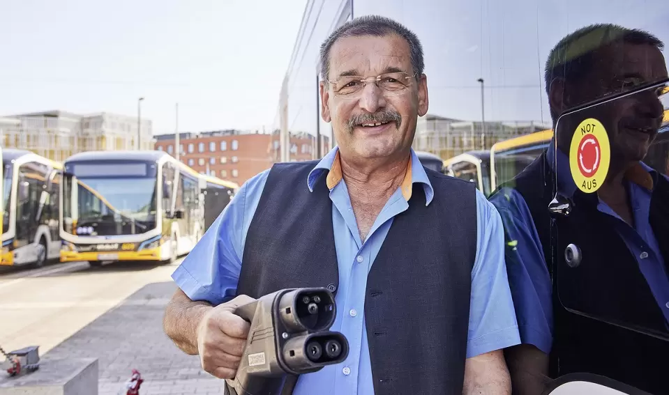 Busfahrer mit Ladekabel in der Hand