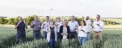 Mehrere Menschen stehen auf einem Feld und werfen Glühlampen in die Luft