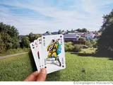 Joker in einem Kartendeck und Häuser im Hintergrund