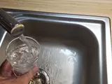 Wasser läuft aus einem Wasserhahn in ein Glas