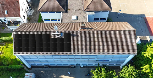 Die Luftaufnahme zeigt das Dach der Grundschule Gau-Bischofsheim, auf dem eine Photovoltaik-Anlage simuliert ist. 