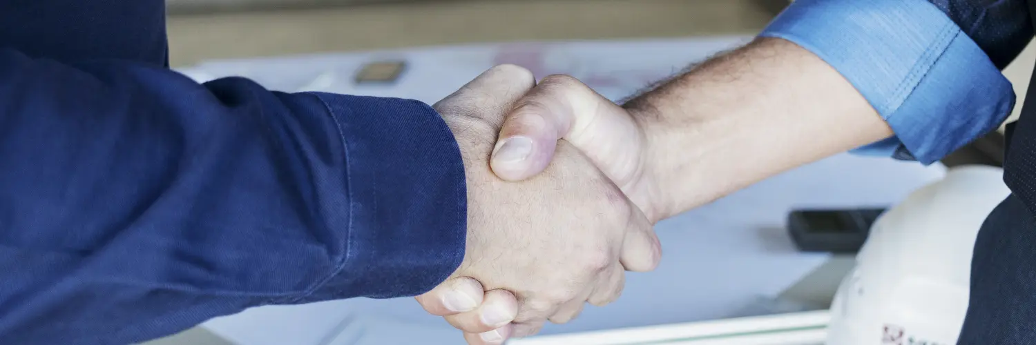 Zwei Menschen geben sich die Hand zum Handschlag